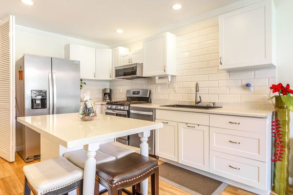Fully Equipped Modern Kitchen with Island Stools and Stainless Steel Appliances