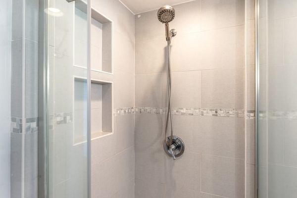 Walk-In Glass Shower with Tiled Enclosure and Wall Niche