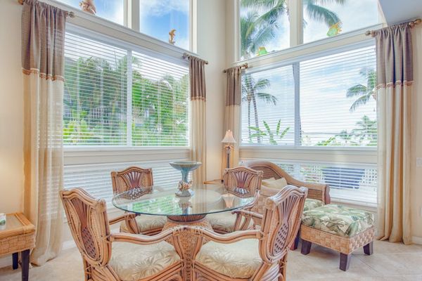 Sunlit Dining Area with Glass-Top Table & Vaulted Windows