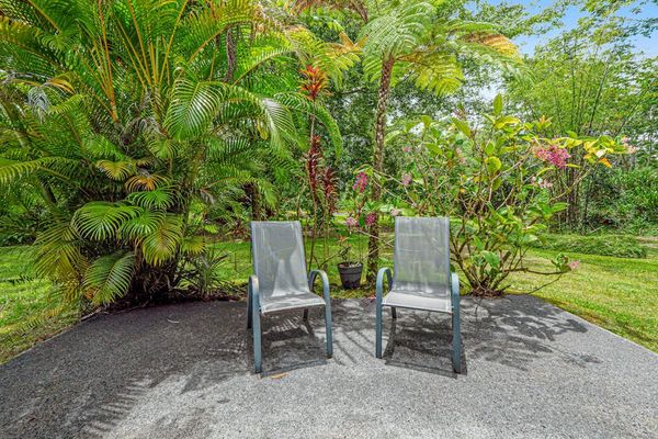 Escape to a private tropical backyard oasis surrounded by lush Hawaiian landscaping, swaying palms, and the peaceful beauty of paradise.