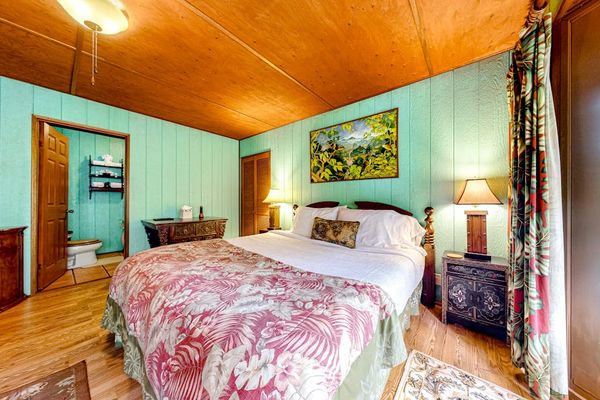 Guest room with a queen bed and large picture windows.