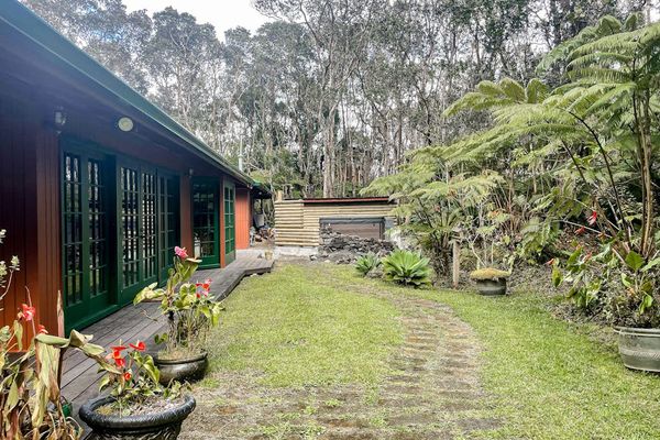 Escape to a private tropical backyard oasis surrounded by lush Hawaiian landscaping, swaying palms, and the peaceful beauty of paradise.