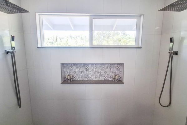 Master en-suite bathroom with double sinks and large walk-in shower with double shower heads.