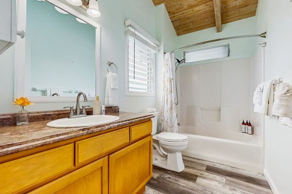 Full bathroom features vanity shower mirror and clean tiled finishes