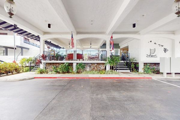 Covered entrance welcomes guests with open seating and tropical surroundings