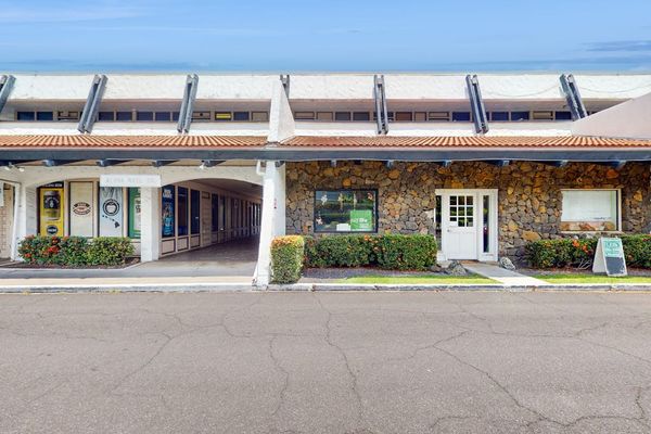Charming stone exterior features covered walkway and landscaped grounds nearby