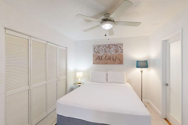 First bedroom offers queen bed ceiling fan and natural light
