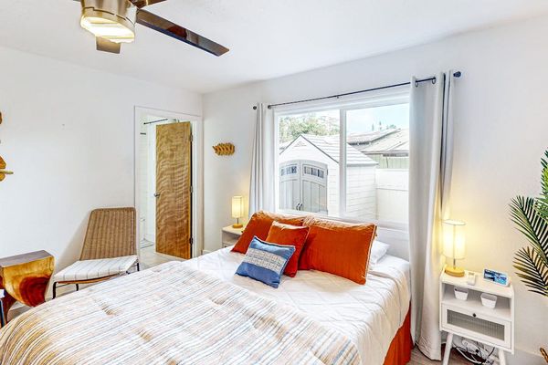 Master bedroom with queen bed with lots of windows for natural light and an en-suite bathroom