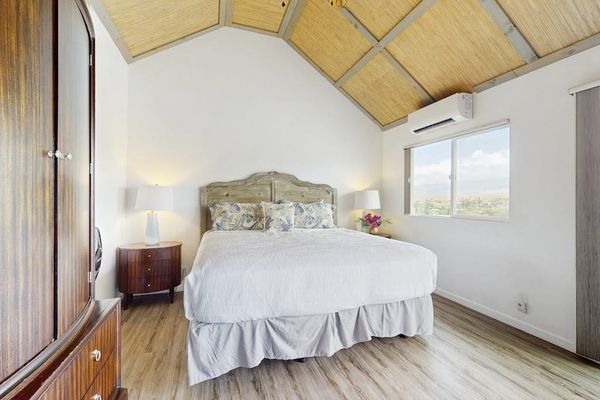 Master bedroom with king bed and vaulted ceilings.