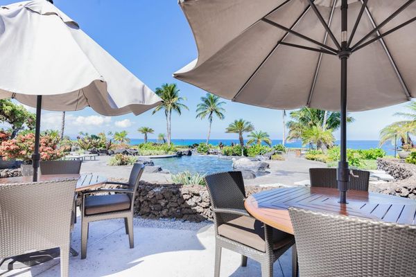 Patio Dining Tables with Umbrellas Overlooking Resort Pool & Ocean