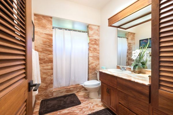 Contemporary bathroom showcases a shower, vanity, and warm tilework