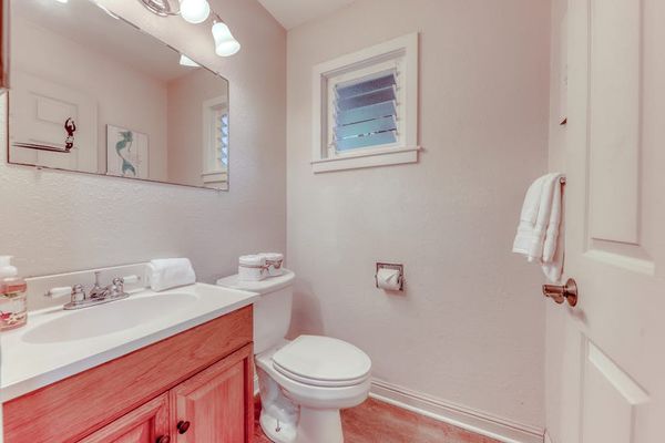 Full Bathroom Featuring Warm Wood Vanity & Wall Mirror