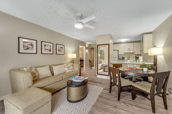 Open-Concept Living and Dining Space with Sofa, Ottoman, and Round Dining Table