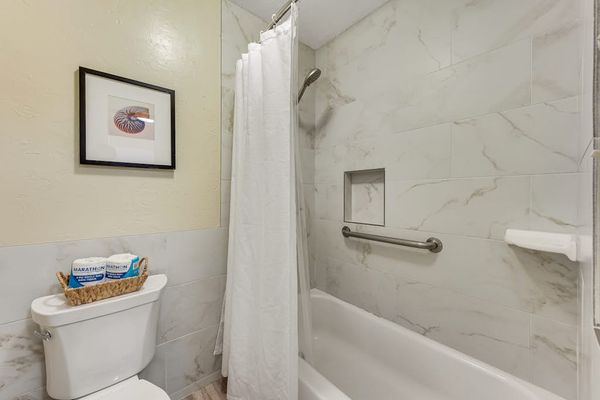 Bathroom Tiled Combination Bathtub and Shower with Grab Bar and Toilet