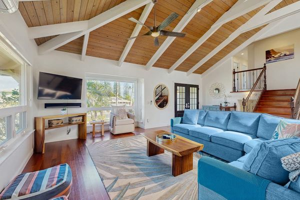 Bright, open living space with cathedral ceilings, skylights, Ipe wood floors, ceiling fans, A/C throughout, and seamless access to the lanai for effortless indoor-outdoor living and beautiful views.