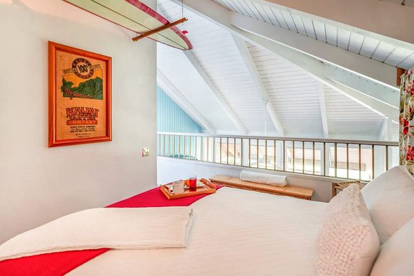 Relax in the cozy guest bedroom with vaulted wood ceilings.