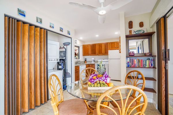 Dining table with wicker seating and views leading into the kitchen