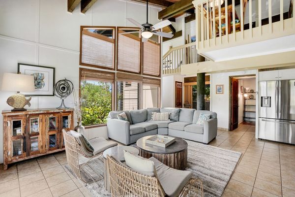 Spacious living room bathed in natural light, featuring comfortable seating and a flat-screen TV for cozy nights in.
