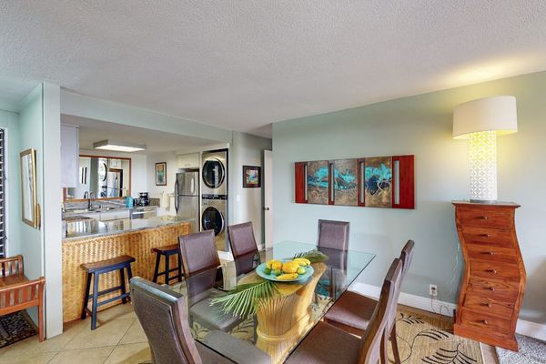 Inviting dining nook sits beside kitchen bar and tropical artwork