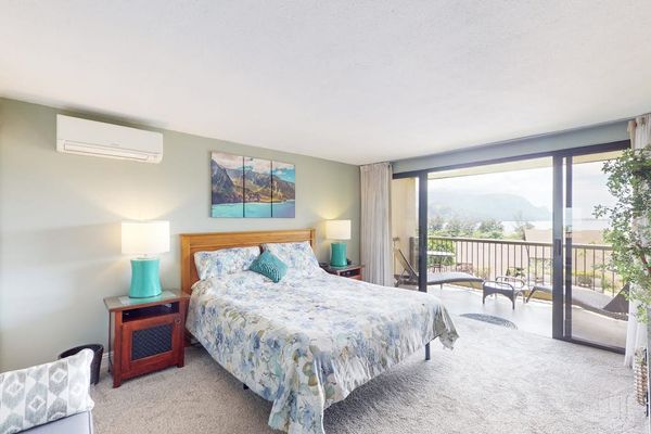 First Bedroom features coastal artwork plush bedding and balcony access