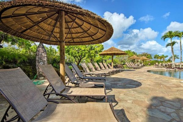 Poolside loungers beneath thatched umbrellas invite relaxing island afternoons outdoors