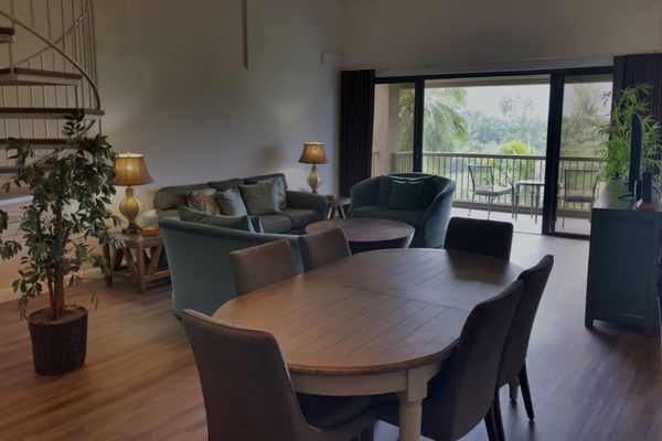 Dining area features round table, comfortable chairs, and balcony access