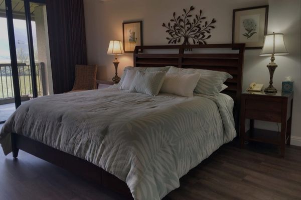 Primary bedroom showcases king bed, bedside tables, and warm lighting
