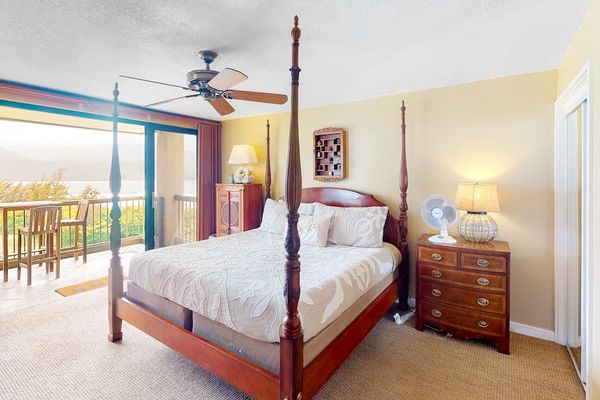 Primary bedroom features canopy bed, ceiling fan, and peaceful decor