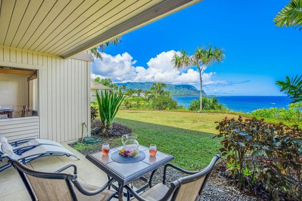 Covered patio showcases tiled flooring, bistro seating, and mountain views