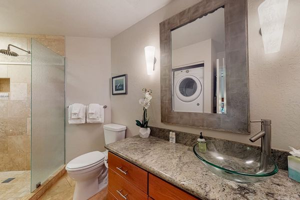 Well-organized bathroom offers a comfortable shower, mirror, and attractive details