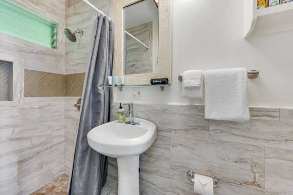 Bright full bathroom with a walk-in shower and fresh towels.