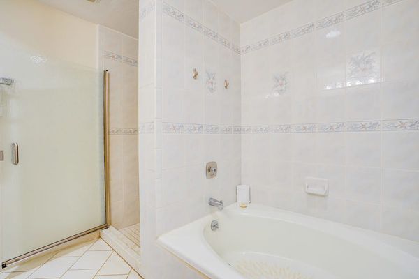 Bright Bathroom featuring Separate Soaking Tub & Glass Enclosed Shower