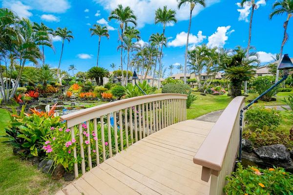Scenic Garden Bridge Surrounded By Tropical Blooms