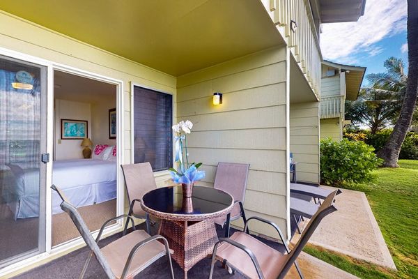 Private lanai with outdoor seating overlooking the tropical grounds.