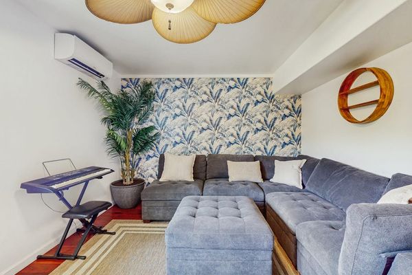 This cozy corner of the rec room features a large gray sectional sofa and a matching ottoman