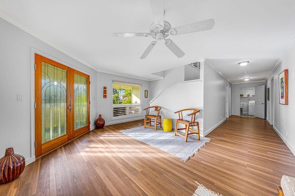Sunlit open hallway and seating area with hardwood flooring