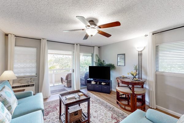 The living area seamlessly opens onto a private lanai with comfortable seating and impressive views of the mountains and surrounding landscape.