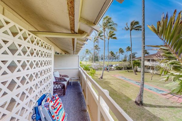 The living area seamlessly opens onto a private lanai with comfortable seating and impressive views of the mountains and surrounding landscape.