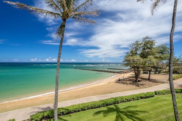 Turquoise water of the Pacific Ocean crashing on to the white sandy beaches while the palm trees sway in the breeze.