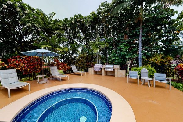 Unwind in the inviting hot tub surrounded by tropical landscaping