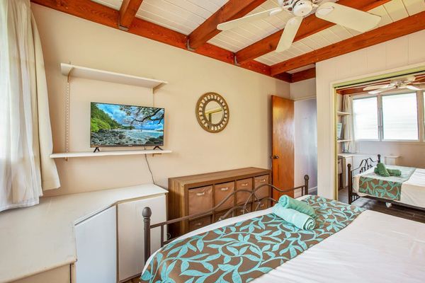Primary bedroom with king bed, flat screen tv and plenty of natural light