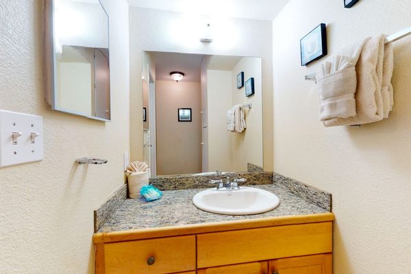Bathroom Vanity Area with Granite Countertop & Bright Lighting