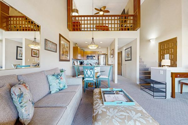 Bright Living Area with Plush Sofa, Loft View, and Entryway