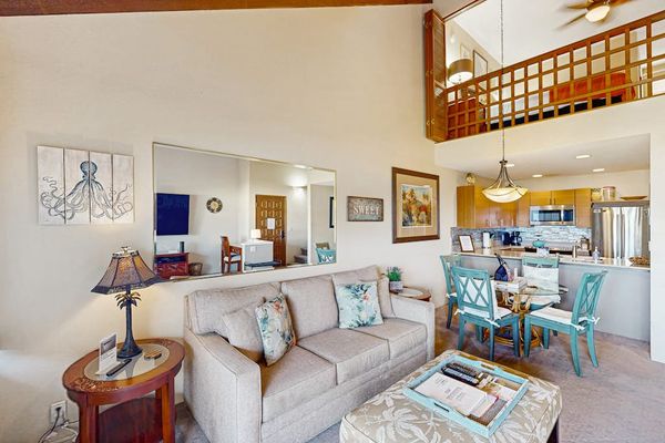 High-Ceiling Open Living Area, Dining Table, and Kitchen View beneath Bedroom Loft