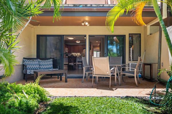 Tropical patio welcomes guests with outdoor seating and landscaped surroundings