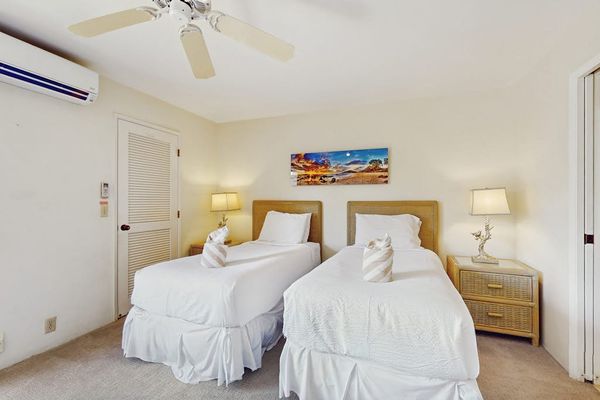 Second Bedroom twin beds rest beneath ceiling fan and artwork