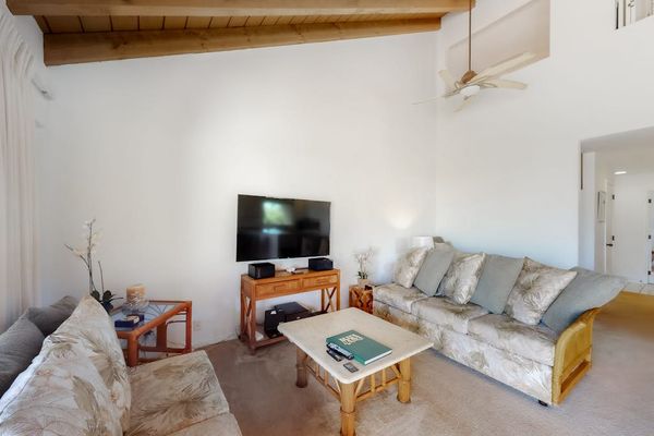 Living room seating and television overlook lush tropical garden scenery