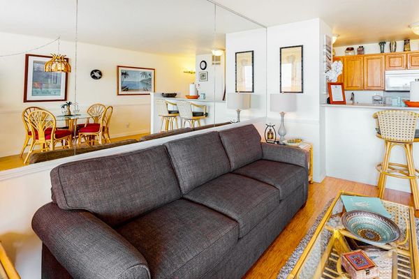 Living room with sleeper sofa and a flat screen tv.  Lots of natural light streaming in from the lanai.