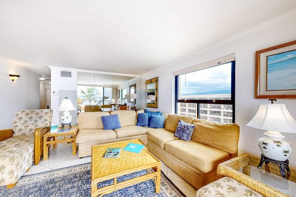 This large living room with a comfortable sectional with views from the open sliders of the lanai.  Turquoise waters as far as the eye could see.
