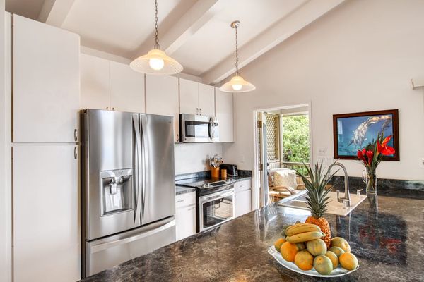Fully Equipped Kitchen featuring Stainless Steel Appliances and Pendant Lights